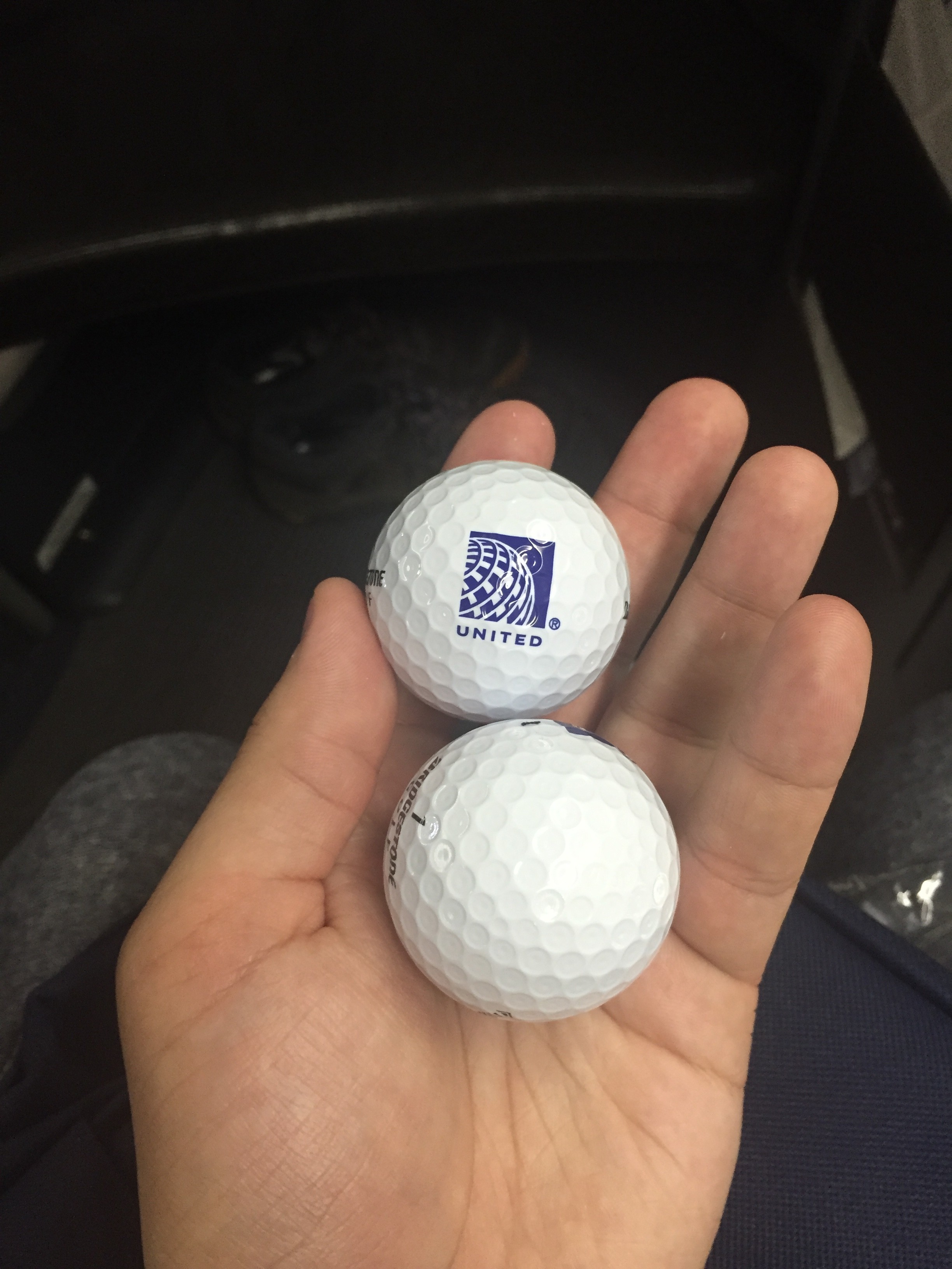 a hand holding two golf balls