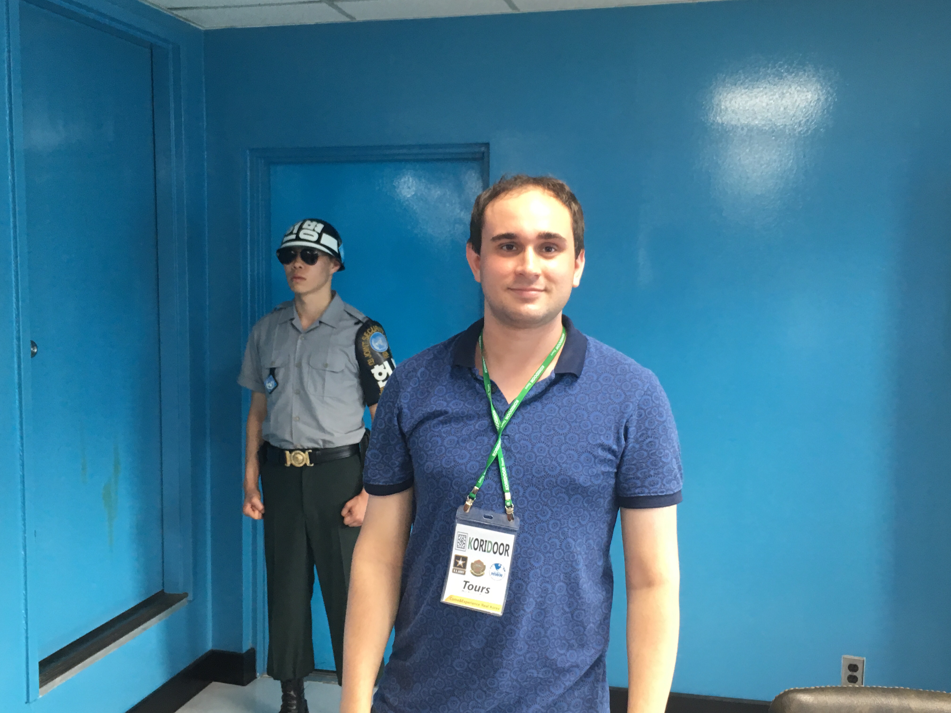 a man standing in a room with a police officer behind him