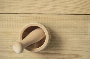 a wooden mortar and pestle on a wood surface