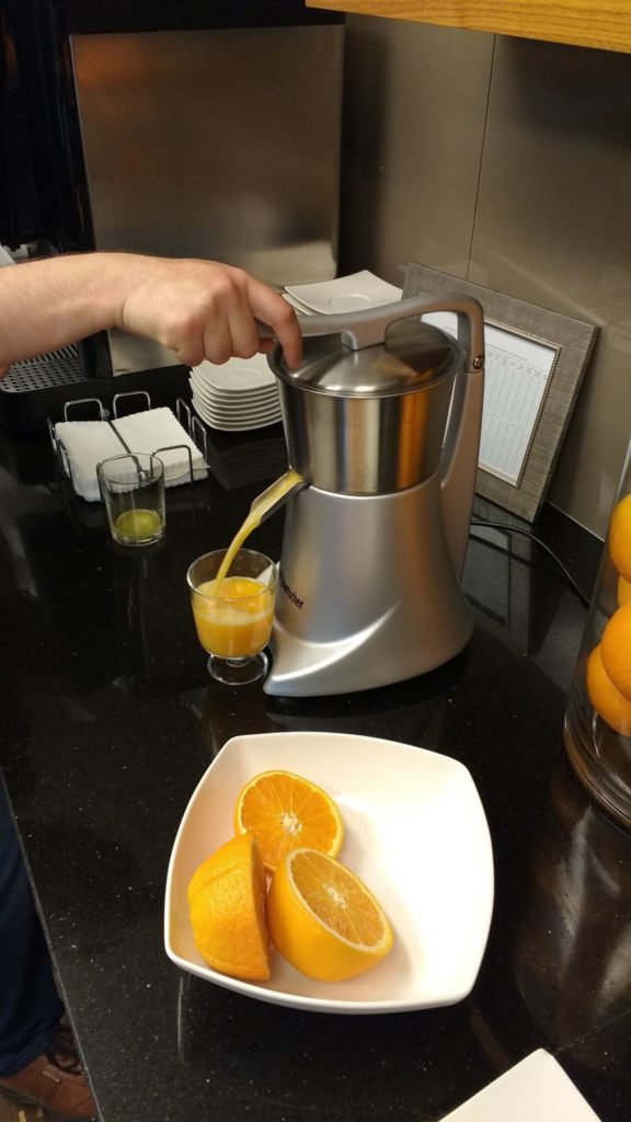 a person pouring orange juice into a glass