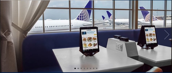 a tablet on a table with an airplane in the background