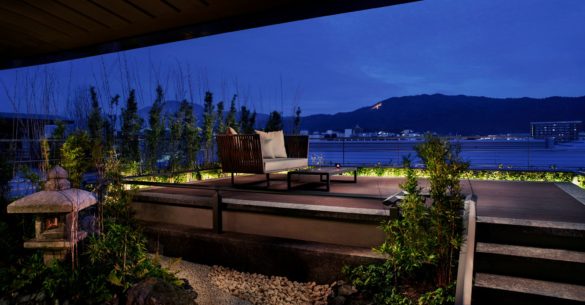 a patio with a chair and a view of the water