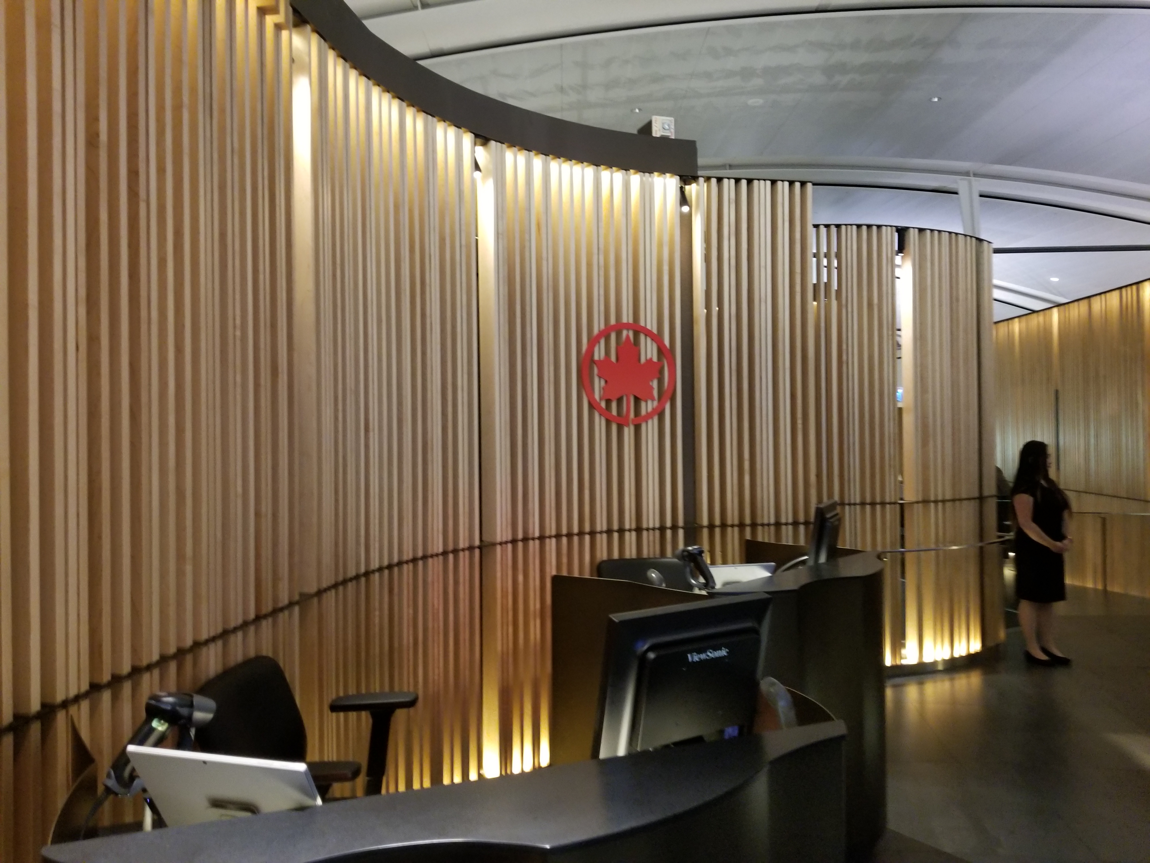a reception area with a red logo on the wall