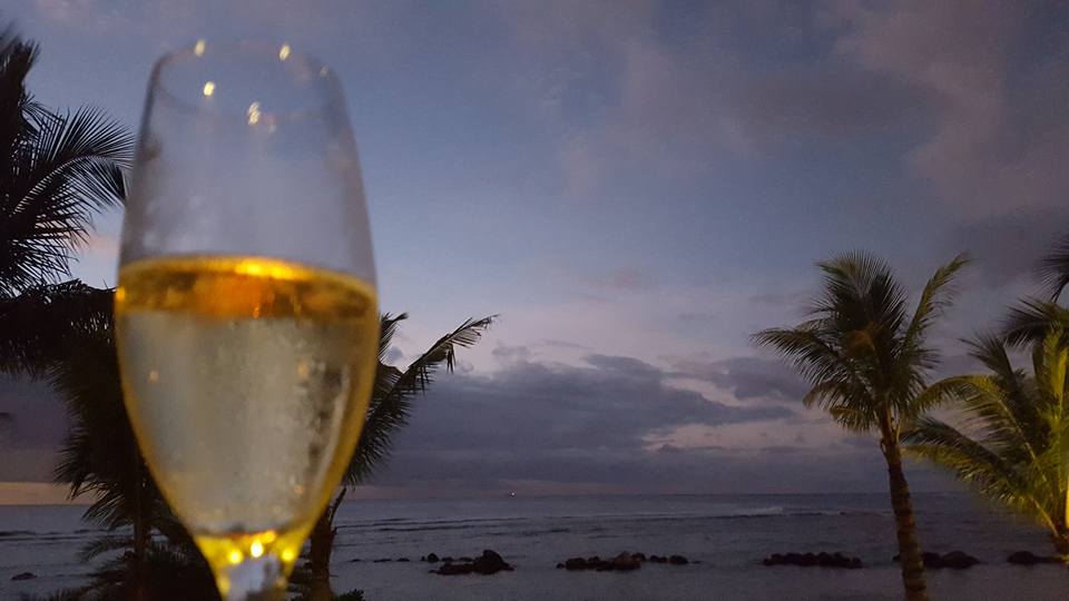 a glass of wine with a body of water in the background